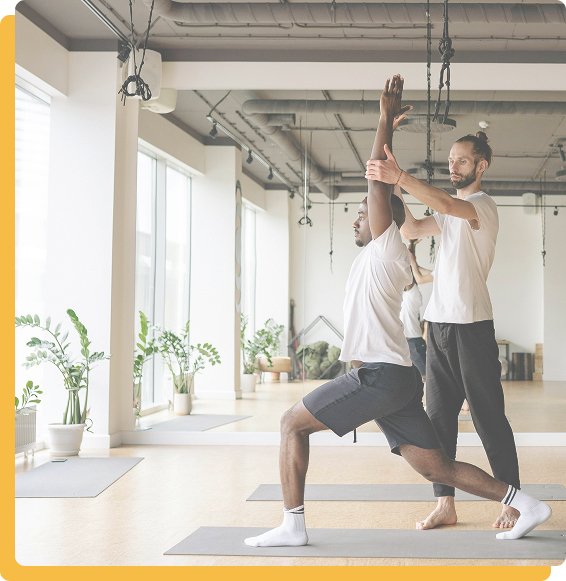 Image d’illustration : coach sportif corrigeant la posture d’une personne dans une salle de sport, ambiance professionnelle et motivante.